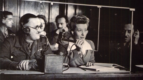 From left, Capt. Macintosh of the British Army translates from French into English, while Margot Bortlin translates from German into English and Lt. Ernest Peter Uiberall monitors the translations at the Nuremberg trials after World War II. (Photo courtesy of Francesca Gaiba)